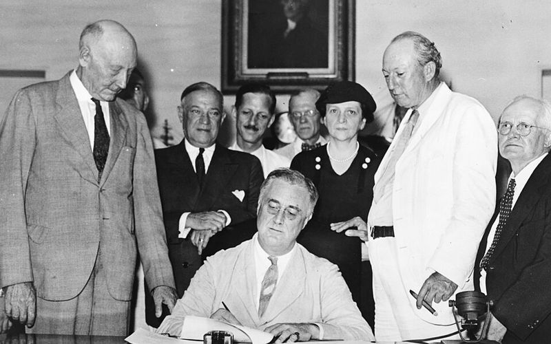 President Franklin Roosevelt signs the Social Security Act, August 14, 1935